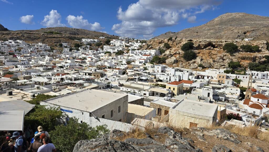 Villaggio di Lindos a Rodi visto dall'alto, durante la discesa dall'Acropoli. Si vedono le tipiche case bianche addossate l'una all'altra e le colline rocciose brulle circostanti.
